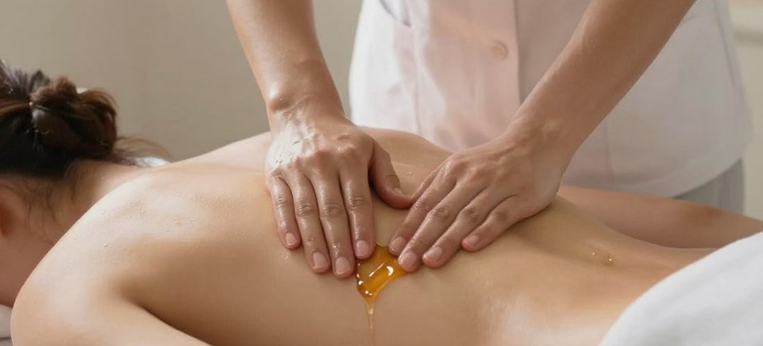 Massage therapist demonstrating b2b massage technique with warm oil